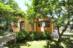 une petite maison jaune avec un arbre dans la cour dans l'établissement Holiday Home Maya, à Medulin