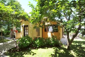 a small yellow house with a tree in the yard at Holiday Home Maya in Medulin