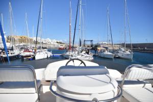 a boat with chairs and boats in a marina at Luxury Yacht Kamikara in San Miguel de Abona
