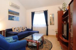 - un salon avec un canapé bleu et une fenêtre dans l'établissement Holiday Home Maya, à Medulin