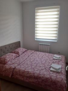 ein Schlafzimmer mit einem Bett mit zwei Handtüchern darauf in der Unterkunft Apartman Garic in Pale