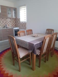 mesa de comedor con sillas y mantel en Apartman Garic en Pale