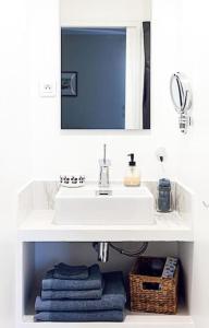 a bathroom with a sink and a mirror and towels at Le Studio de la Rue Mounié in Antony