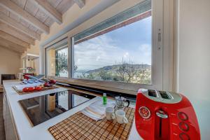 una cucina con una grande finestra e un apparecchio rosso di Casa Paradiso a Camogli