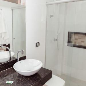 een badkamer met een wastafel en een glazen douche bij Castelar Novo Hotel in Varginha