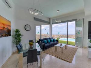 ein Wohnzimmer mit einem blauen Sofa und einem Tisch in der Unterkunft Villa Calm Ocean views by Infinity Summer in La Playa de Arguineguín