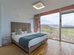 ein Schlafzimmer mit einem großen Bett und großen Fenstern in der Unterkunft Villa Calm Ocean views by Infinity Summer in La Playa de Arguineguín