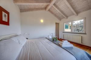una camera da letto con un grande letto bianco e una finestra di Casa Paradiso a Camogli