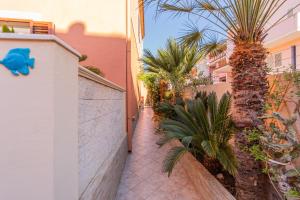 a alley with palm trees next to a building at Casa Maria in La Maddalena