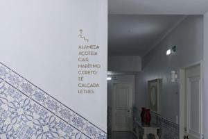 een trap met een muur met opschriften op de muur bij Palacete da Baixa by MY CHOICE in Faro