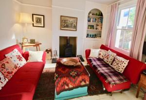 een woonkamer met een rode bank en een tafel bij Rumbosun in Kingsdown