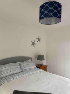 a bedroom with a bed with a blue lamp and stars on the wall at No. 19 in Rostrevor