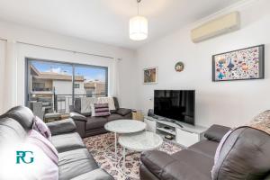 a living room with a couch and a tv at Luxury Penthouse Near City Center #1933 in Lagos