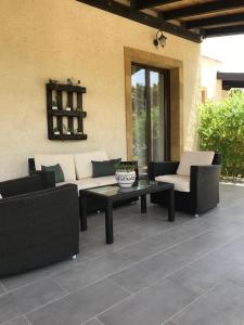 un patio con sofá, mesa y sillas en Villa Agape, en Marina di Noto
