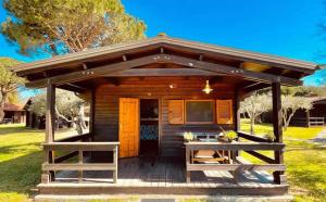 a wooden cabin with a porch and a table at Le Dune Villaggio in Lido Di Fondi