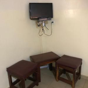 a room with a table and two stools and a tv at Lodge Kabacoto in Nioro du Rip