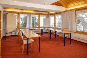 ein Klassenzimmer mit Tischen, Stühlen und Fenstern in der Unterkunft Hotel und Restaurant Chäseren in Schönengrund