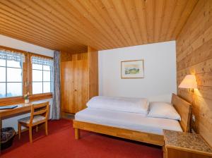 a small bedroom with a bed and a desk at Hotel und Restaurant Chäseren in Schönengrund