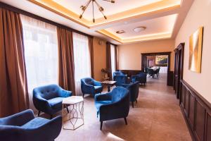 uma sala de espera com cadeiras e mesas azuis em Wellness Hotel Pivovar Monopol em Teplice