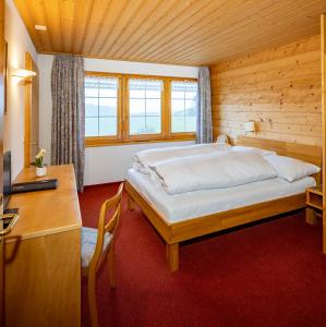 1 dormitorio con 1 cama y escritorio con escritorio en Hotel und Restaurant Chäseren, en Schönengrund