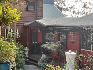 uma casa com uma porta vermelha e algumas plantas em Tambaridge Bed & Breakfast em Eagle Heights