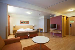 a hotel room with a bed and a tv at Hotel Kajanus in Kajaani