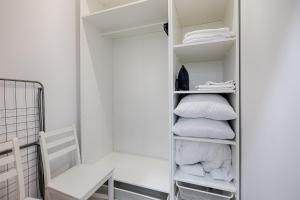 a closet with a mirror and white pillows at Piotrkowska Street III by LookAp in Łódź