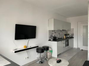 a white kitchen with a tv on the wall at Beautiful Penthouse Lakeview W18 in Bucharest