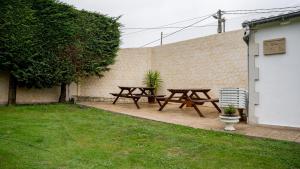 two picnic tables and a bench in a backyard at La casa de Virginia in Torrelavega