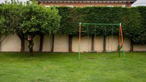a swing set in a yard with a hedge at La casa de Virginia in Torrelavega