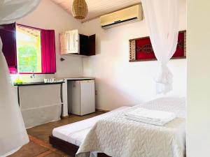 a small room with a bed and a kitchen at Gostoso Familly Chalés - Beira Mar in São Miguel do Gostoso