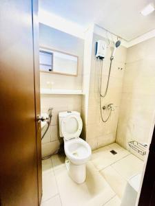 ein Bad mit einem WC und einer Dusche in der Unterkunft Cozy Place Anuva Residences in Manila