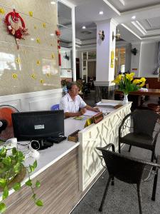 a man sitting at a desk in an office with a laptop at Bao Chieu Inn in Ha Tien