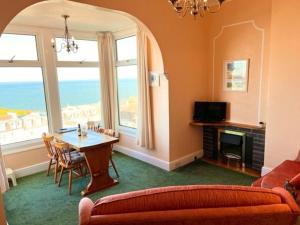 uma sala de estar com uma mesa e um sofá em Ocean View em Ilfracombe