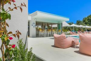 a patio with pink pillows and a table and chairs at Cocoοns Suites & Villas Fourka in Fourka
