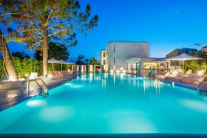 a swimming pool at night with chairs and umbrellas at Cocoοns Suites & Villas Fourka in Fourka