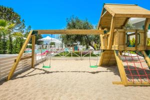 a playground with a swing set in the sand at Cocoοns Suites & Villas Fourka in Fourka