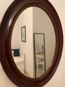 ein Spiegel hängt an einer Wand in einem Zimmer in der Unterkunft Belle Donne Historical Apartment - City Center in Florenz