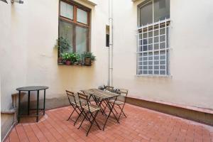 eine Terrasse mit einem Tisch, Stühlen und einem Fenster in der Unterkunft Belle Donne Historical Apartment - City Center in Florenz