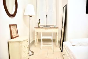 einen weißen Schreibtisch in einem Schlafzimmer mit Spiegel in der Unterkunft Belle Donne Historical Apartment - City Center in Florenz