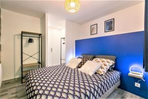 een slaapkamer met een blauwe muur en een bed bij Appart Disney T3 Sweet place in Montévrain