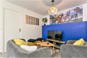 een woonkamer met een bank en een tv bij Appart Disney T3 Sweet place in Montévrain