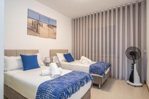 a bedroom with two beds and a fan at Blue Paradise Apartment in Caniço