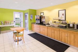 a kitchen with green walls and a table and a counter at Microtel Inn & Suites by Wyndham Delphos in Delphos
