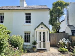 a white house with a white door and a fence at Cliffeside Cottage in Kingsdown