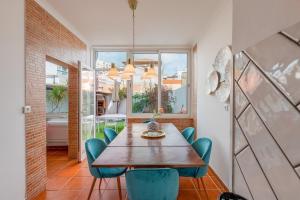 uma sala de jantar com uma mesa de madeira e cadeiras azuis em Setúbal Oasis House em Setúbal