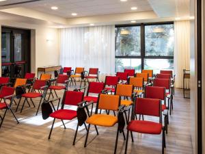 a room with chairs and a podium in it at Ibis Roma Fiera in Rome