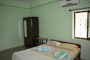 a bedroom with a bed with two towels on it at Vailankanni Guesthouse in Morjim