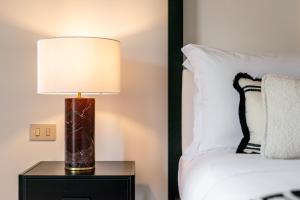 una lampada su un comodino accanto a un letto di The Couper Bagutta a Milano