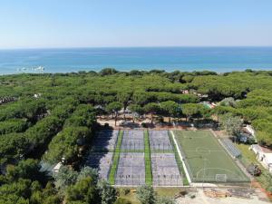 eine Luftansicht auf einen Tennisplatz und das Meer in der Unterkunft Le Dune Villaggio in Lido Di Fondi